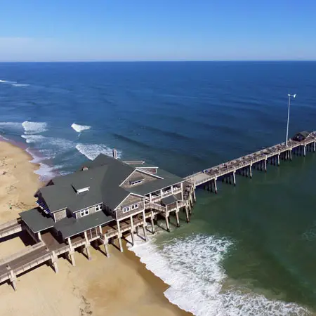An aerial view of Jennette's Pier reaching out over the Atlantic, directly across from Seahorse Inn & Cottages in Nags Head
